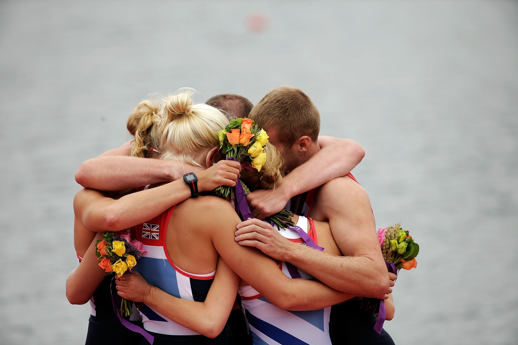 Team GB rowers embrace with their medals and flowers at London 2012